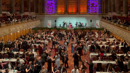 Eleganter Ballsaal mit tanzenden Paaren und Liveband im Hintergrund